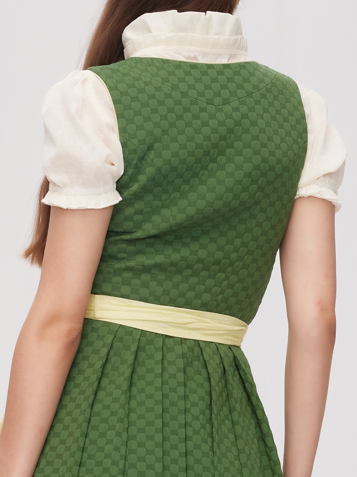 Ein schwarzes Dirndl aus Samt mit grüner Schürze, perfekt für festliche Anlässe